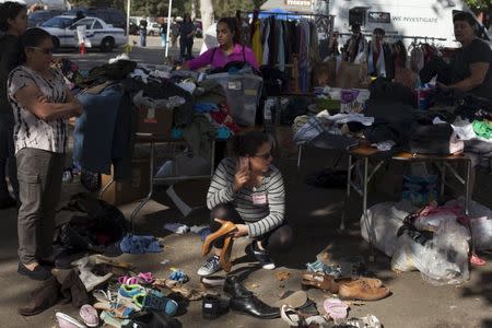 Volunteer Sandra Recinos (C) sorts shoes and other donated items at an evacuation center for residents affected by the Valley Fire, at the Napa County Fairgrounds in Calistoga, California September 15, 2015. REUTERS/David Ryder