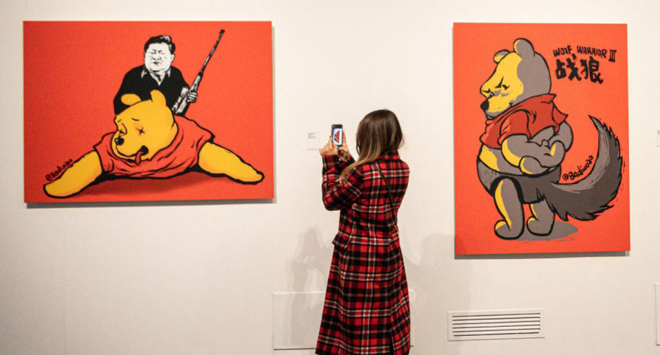 A visitor takes photos of &#39;Winnie the Trophies, 2017 by Chinese artist Badiucao on November 12, 2021 at an exhibition in Brescia, Lombardy. Source: Piero Cruciatti via AFP/Getty Images