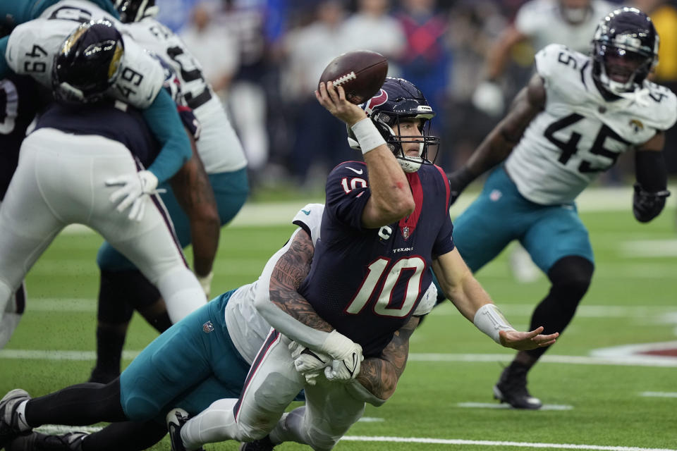 Houston Texans quarterback Davis Mills (10) is hit by Jacksonville Jaguars defensive end Adam Gotsis, left, as he tris to pass during the second half of an NFL football game in Houston, Sunday, Jan. 1, 2023. (AP Photo/David J. Phillip)