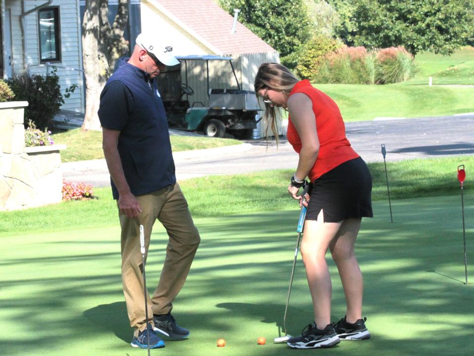 Sturgis golf coach Ken Schau works with Aspen Hyska on the putting green at Klinger Lake Country Club on Tuesday.