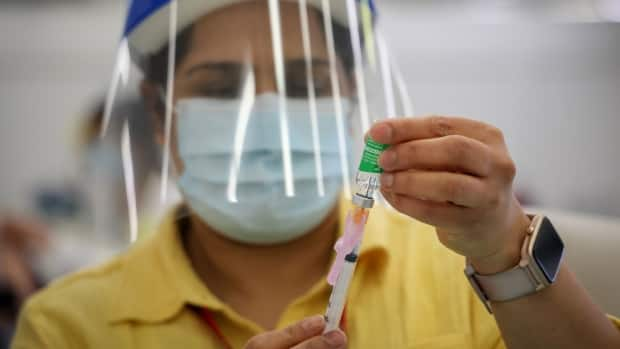 A health-care worker prepares a shot of the AstraZeneca/COVISHIELD COVID-19 vaccine. (AHS - image credit)