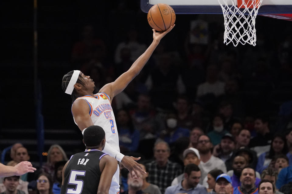 Oklahoma City Thunder guard Shai Gilgeous-Alexander (2) goes to the basket in front of Sacramento Kings guard De'Aaron Fox (5) in the first half of an NBA basketball game Monday, Feb. 28, 2022, in Oklahoma City. (AP Photo/Sue Ogrocki)