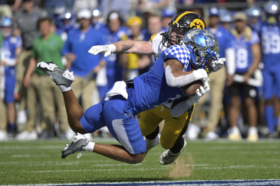 Kentucky wide receiver Wan'Dale Robinson (1) catches a pass in front of Iowa defensive back Jack Koerner (28) for a 34-yard gain during the first half of the Citrus Bowl NCAA college football game, Saturday, Jan. 1, 2022, in Orlando, Fla. (AP Photo/Phelan M. Ebenhack)