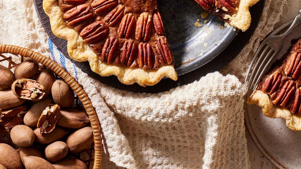 pecan brownie pie in a metal pie plate with a slice removed and on a plate next to it