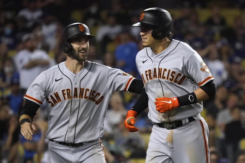 San Francisco Giants' Wilmer Flores, right, celebrates his two-run home run with Steven Duggar during the ninth inning of the team's baseball game against the Los Angeles Dodgers on Wednesday, July 21, 2021, in Los Angeles. (AP Photo/Marcio Jose Sanchez)