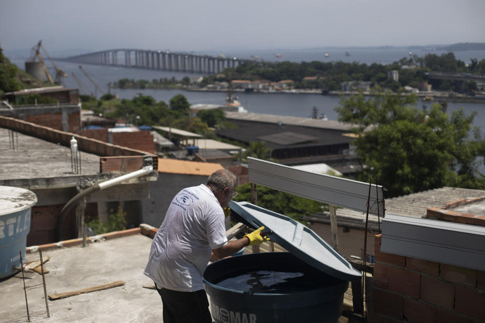 Augusto César, trabajador municipal que combate enfermedades endémicas, revisa un tinaco donde los mosquitos pueden dejar huevos, en la favela de Morro da Penha, en Niterói, Brasil, el viernes 1 de marzo de 2024. (AP Foto/Bruna Prado)