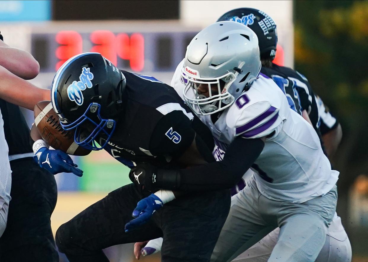 Bloomington South’s Ralph Rogers (0) tackles Columbus North’s Gino Prescott (5) during the football game against Columbus North at North on Friday, Sept. 29, 2023.