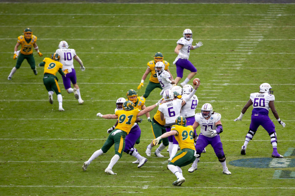 James Madison quarterback Ben DiNucci (6) throws a pass as North Dakota State defensive end Derrek Tuszka (91) attempts to tackle him during the first half of the FCS championship NCAA college football game, Saturday, Jan. 11, 2020, in Frisco, Texas. (AP Photo/Sam Hodde)