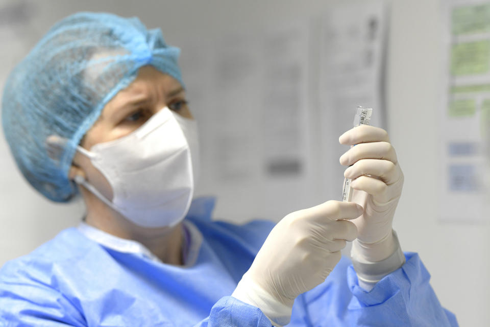 A nurse holds a vial containing the first five doses of COVID-19 vaccine administered in the country in Bucharest, Romania, Sunday, Dec. 27, 2020. (AP Photo/Andreea Alexandru)