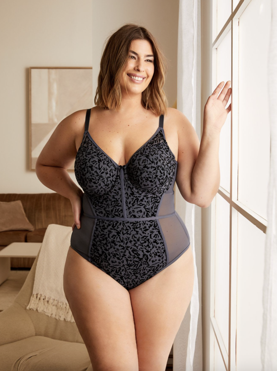 plus size brunette model in navy and black Déesse Boudoir Mesh Bodysuit (Photo via Penningtons)