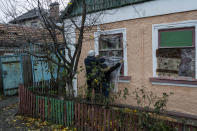 Residents cover their windows with plastic sheets the day after the house was damaged during a Russian attack in Kherson, southern Ukraine, Friday, Nov. 25, 2022. (AP Photo/Bernat Armangue)