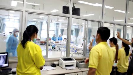 FILE PHOTO: A screen grab shows people looking through glass at the boys rescued from the Thai cave at a hospital in Chiang Rai, Thailand from a July 11, 2018 handout video. Government Public Relations Department (PRD) and Government Spokesman Bureau/Handout via REUTERS TV