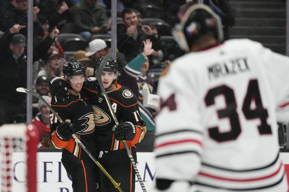 Anaheim Ducks' Isac Lundestrom (21) celebrates after his goal with Trevor Zegras (11) as Chicago Blackhawks goaltender Petr Mrazek (34) stands in front of his net during the first period of an NHL hockey game Monday, Feb. 27, 2023, in Anaheim, Calif. (AP Photo/Jae C. Hong)