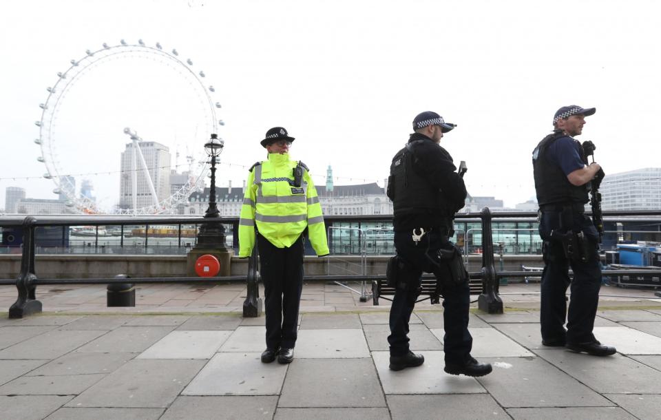 The morning after, armed police stand on The Embankment