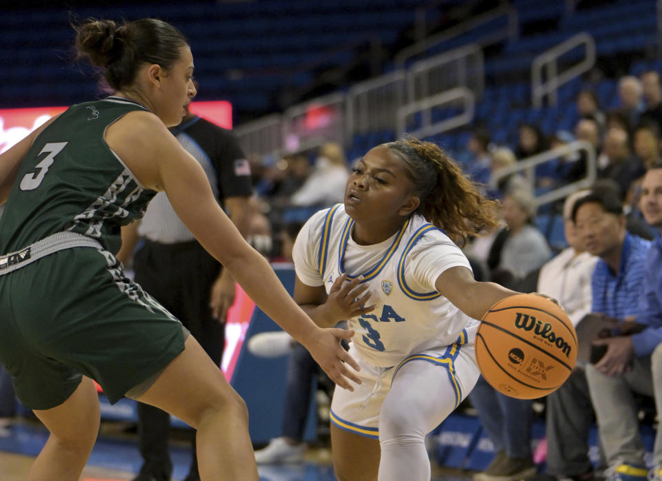 UCLA guard Londynn Jones, right, passes the ball around Hawaii guard Lily Wahinekapu, left, in the first half of an NCAA college basketball game Thursday, Dec. 21, 2023, in Los Angeles. (AP Photo/Jayne Kamin-Oncea)