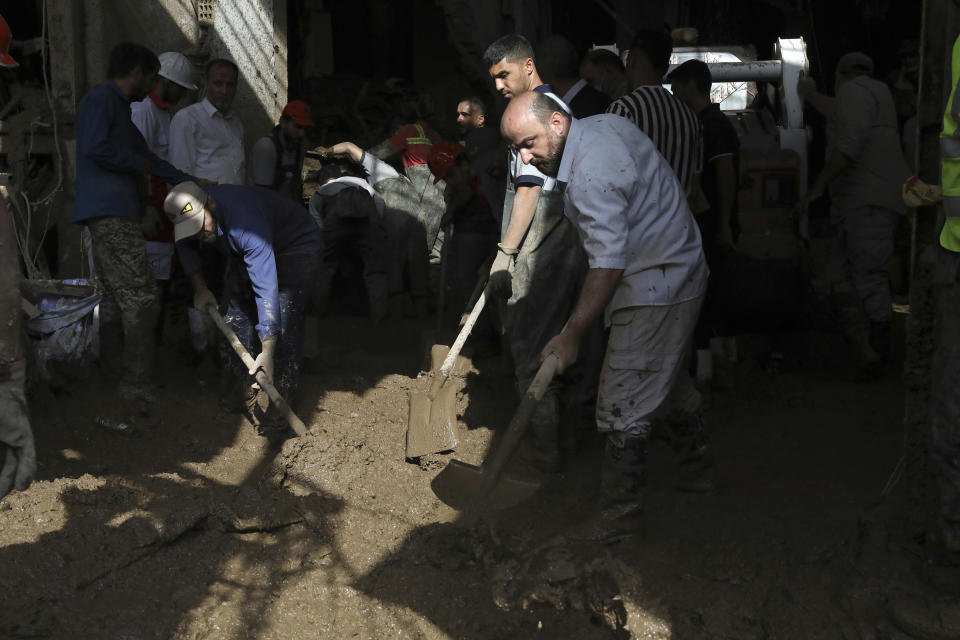 Rescue workers and others clear mud after flash flooding at Imamzadeh Davood village in the northwestern part of Tehran, Iran, Thursday, July 28, 2022. Heavy rains in the early hours of Thursday caused flash floods and then landslides and caused damage to Imamzadeh Davood, a religious shrine in the city. (AP Photo/Vahid Salemi)