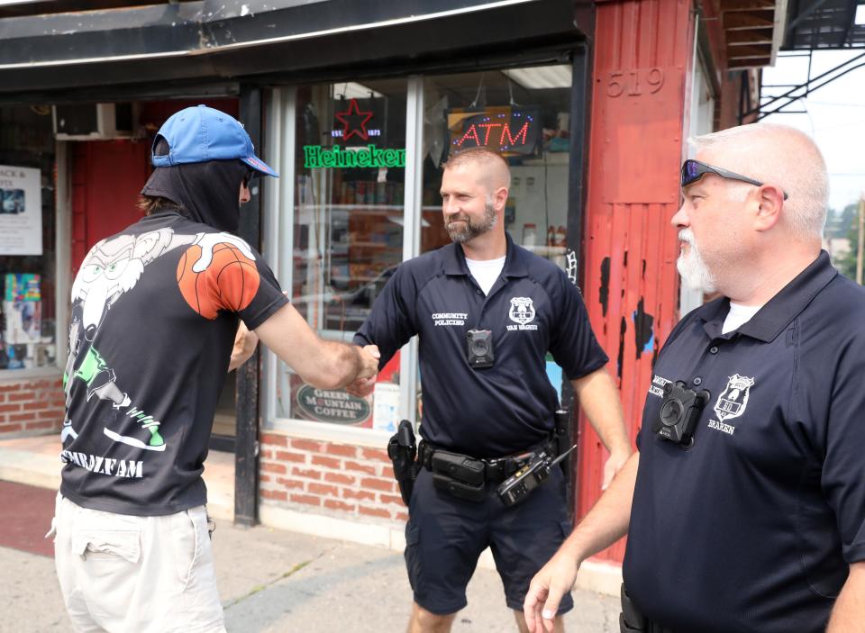 City of Poughkeepsie Police officers, from left, Kevin Van Wagner and Mike Braren talk with resident, Bartholomew Meyer while on patrol along Main Street on July 20, 2021. 