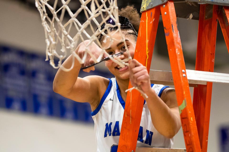 Marian's Shayla Alexander (23) cuts a piece of the net after winning the Marian vs. Saint Joseph girls sectional championship basketball game Saturday, Feb. 4, 2023 at Marian High School.