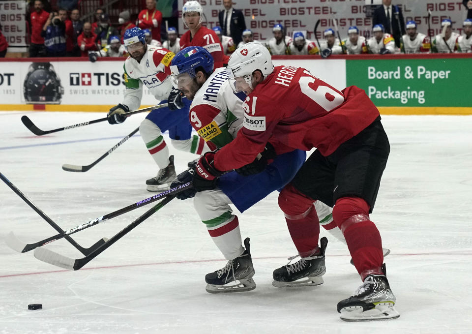 Fabrice Herzog of Switzerland is challenged by Italy's Daniel Mantenuto during the group A Hockey World Championship match between Switzerland and Italy in Helsinki, Finland, Saturday May 14, 2022. (AP Photo/Martin Meissner)