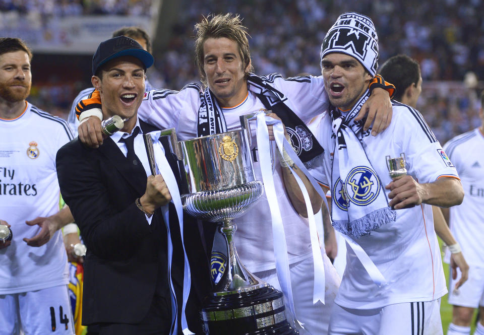 Real's Cristiano Ronaldo, Fabio Coentrao and Pepe, from left to right celebrate with the trophy at the end of the final of the Copa del Rey between FC Barcelona and Real Madrid at the Mestalla stadium in Valencia, Spain, Wednesday, April 16, 2014. Real defeated Barcelona 2-1. (AP Photo/Manu Fernandez)