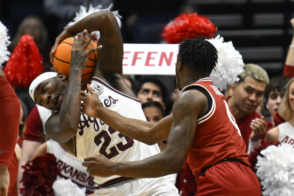 Texas A&M guard Tyrece Radford (23) tries to keep the ball away from Arkansas guard Davonte Davis during the first half of an NCAA college basketball game in the quarterfinals of the Southeastern Conference Tournament, Friday, March 10, 2023, in Nashville, Tenn. (AP Photo/John Amis)