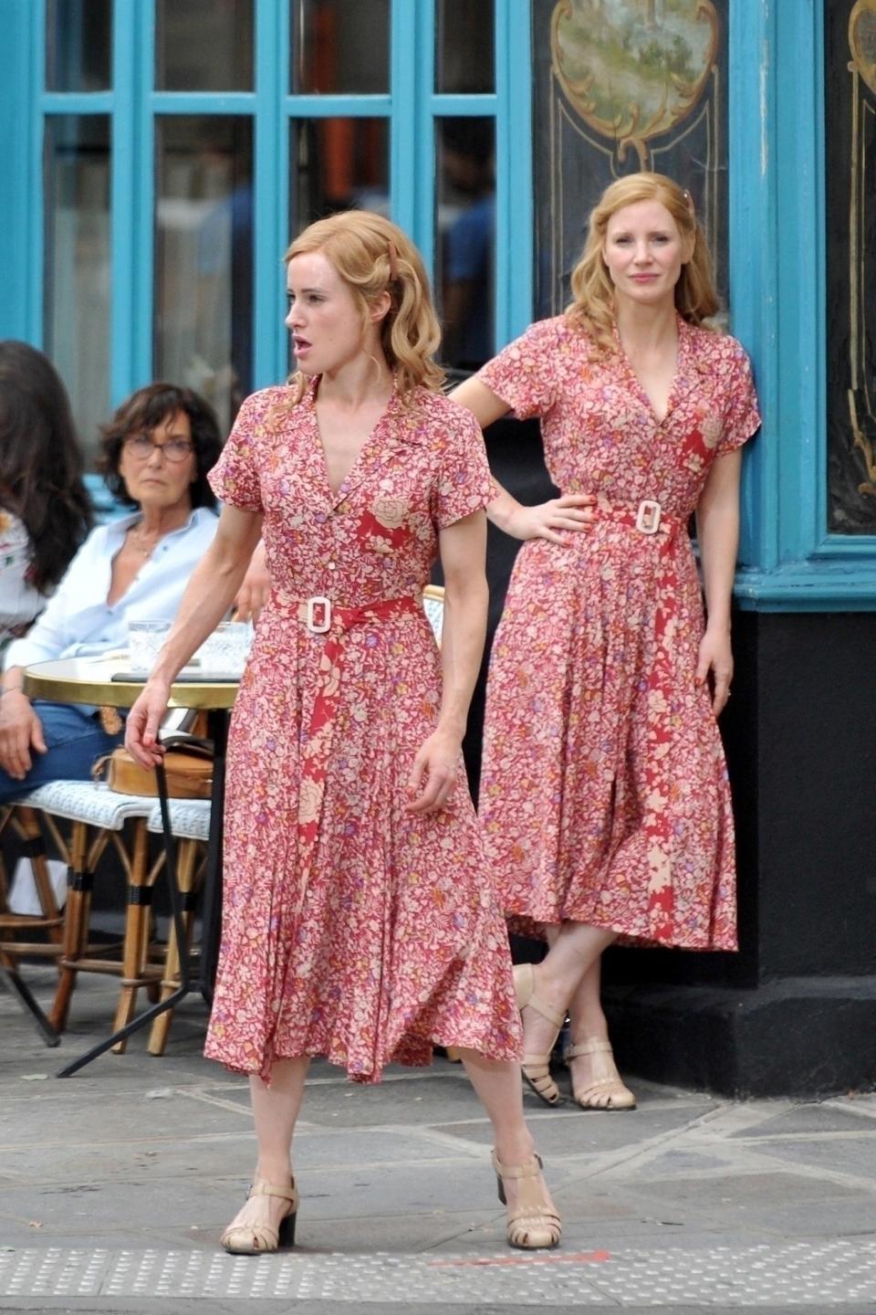 Jessica and her body double in print dresses and sandals