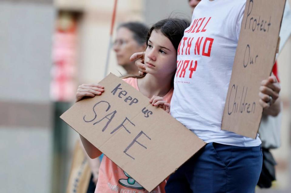 Adeline Sanders, 9, and her mother, Melony Malloy listen to speakers during a vigil for victims of gun violence at Bicentennial Plaza in Raleigh, N.C., Thursday, May 26, 2022.