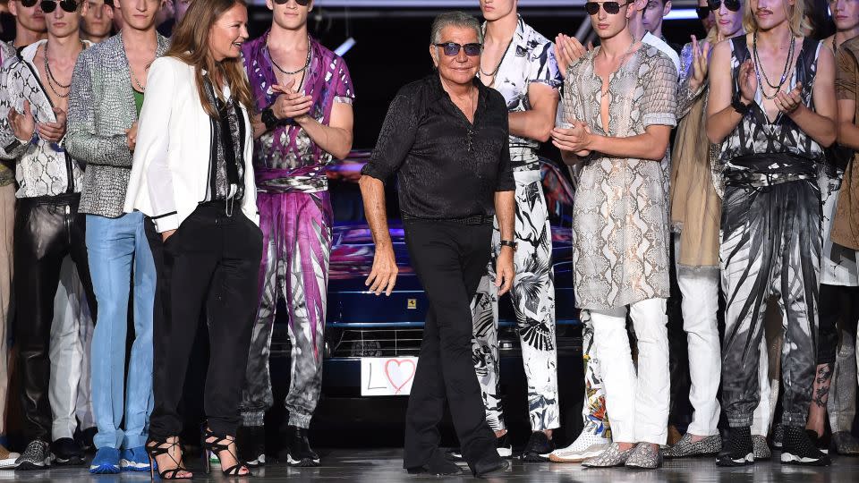 Flanked by models in quintessential Cavalli florals and animal prints, Roberto Cavalli takes his bow after his label's Spring-Summer 2015 menswear show at Milan Fashion Week on June 24, 2014. - Daniele Venturelli/WireImage/Getty Images