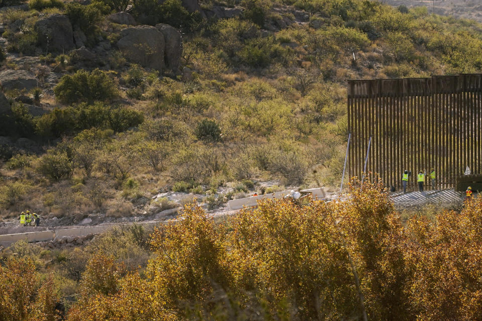 With Mexico to the top, border wall construction continues along a cleared pathway, Wednesday, Dec. 9, 2020, in Guadalupe Canyon, Ariz. Construction of the border wall, mostly in government owned wildlife refuges and Indigenous territory, has led to environmental damage and the scarring of unique desert and mountain landscapes that conservationists fear could be irreversible. (AP Photo/Matt York)