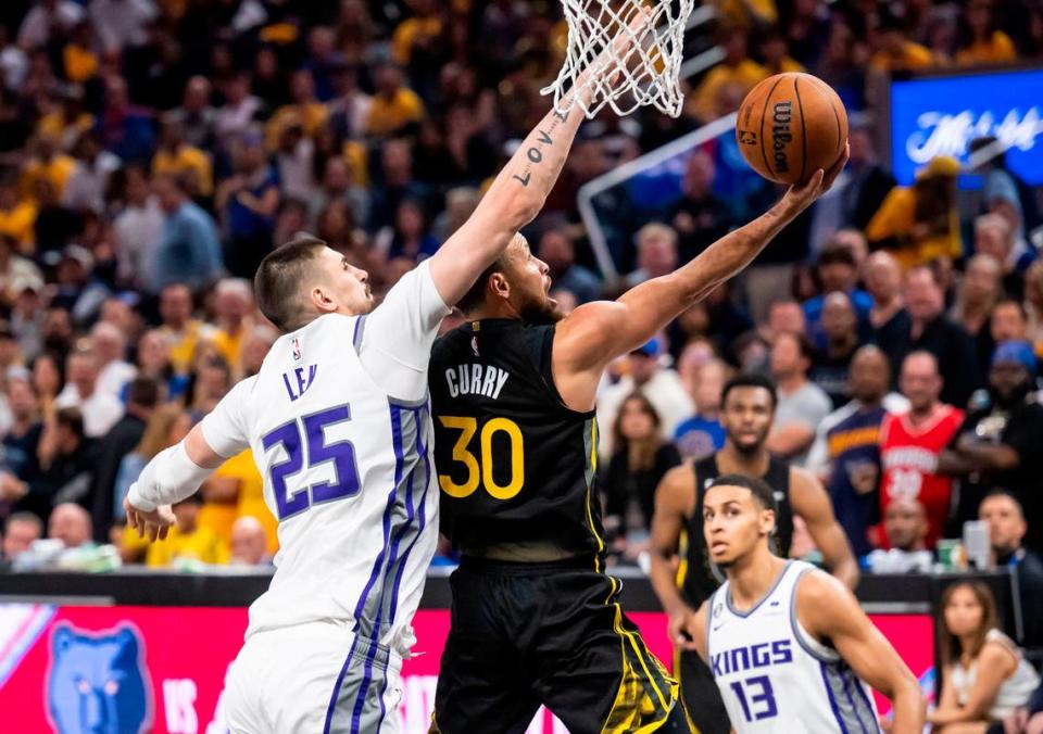 Golden State Warriors guard Stephen Curry (30) goes for a layup ahead of Sacramento Kings center Alex Len (25) during the second half of Game 3 of the first-round NBA playoff series at Chase Center in San Francisco on Thursday, April 20, 2023.