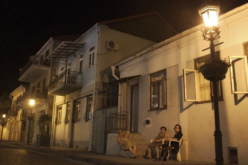 In this July 31, 2012, photo, three women sit at a table and talk on a central street in the Georgian Black Sea resort of Batumi. The transformation of Batumi, an ancient city of 180,000 near the border with Turkey, is a vivid example of Georgia’s drive to capitalize on it tourism potential in a bid to boost the economy in this struggling ex-Soviet nation, where nearly 1/5 of the population lives in poverty, according to conservative estimates. The government has attracted top foreign investors, such as U.S. estate magnate Donald Trump, to build hotels and develop and renovate tourist sites and aggressively marketed Georgia as tourism hot spot abroad. (AP Photo/Maria Danilova)