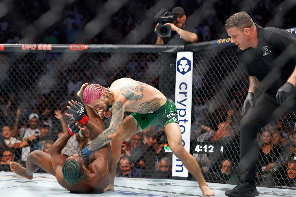 Sean O'Malley, top, lands punches after knocking down Aljamain Sterling during their UFC 292 Bantamweight title mixed martial arts fight, Saturday, August 19, 2023, in Boston. O'Malley won the title via 2nd round KO. (AP Photo/Gregory Payan),.