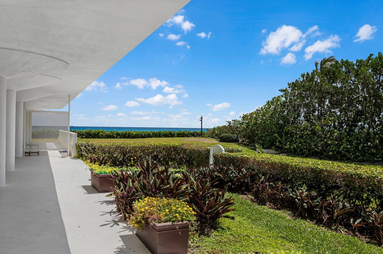 The condo's covered patio fronts a private hedged garden area with an ocean view and a gate that provides access to the lawn.