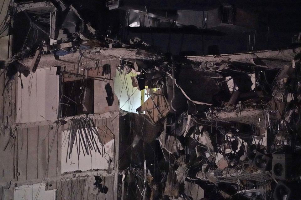 A light glows in a partially collapsed building early Thursday, June 24, 2021, in Surfside area of Miami, Fla.