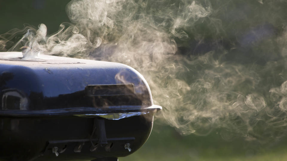 A smoking grill with the lid closed