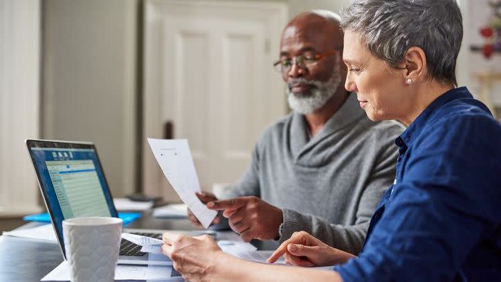 A couple reviews their retirement accumulation plan by looking over how much they're each contributing to their retirement savings accounts. 