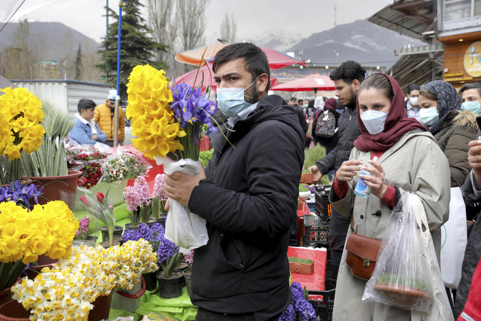 Customers buy flowers to celebrate the Persian New Year, or Nowruz, meaning "New Day." in northern Tajrish Square, Tehran, Iran, Wednesday, March 17, 2021. (AP Photo/Ebrahim Noroozi)