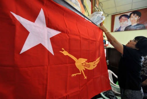 Members of Myanmar's opposition National League for Democracy (NLD) show their new emblem on a party flag at the NLD headquarters in Yangon on December 12, 2011. Myanmar authorities have given the green light to Aung San Suu Kyi's opposition to rejoin mainstream politics, setting the scene for the Nobel laureate to run for a seat in the new parliament