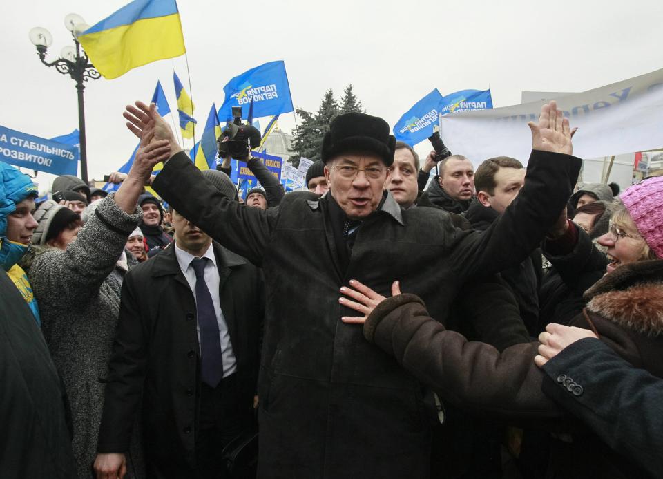 Ukraine's PM Azarov greets supporters of the pro-presidential Party of the Regions as they take part in a rally near the Parliament building in Kiev