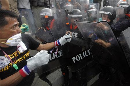 An anti-government protester fights with the police at the barricade near the Government house in Bangkok November 25, 2013. REUTERS/Kerek Wongsa