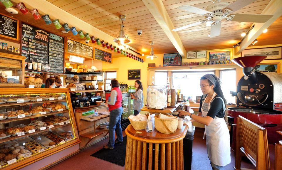 Pie in the Sky employee Giuliana Hulten, right, restocks napkins at right, as customers place orders in the Woods Hole landmark coffee shop which reopened after major renovations, as shown in this April 2017 file photo.