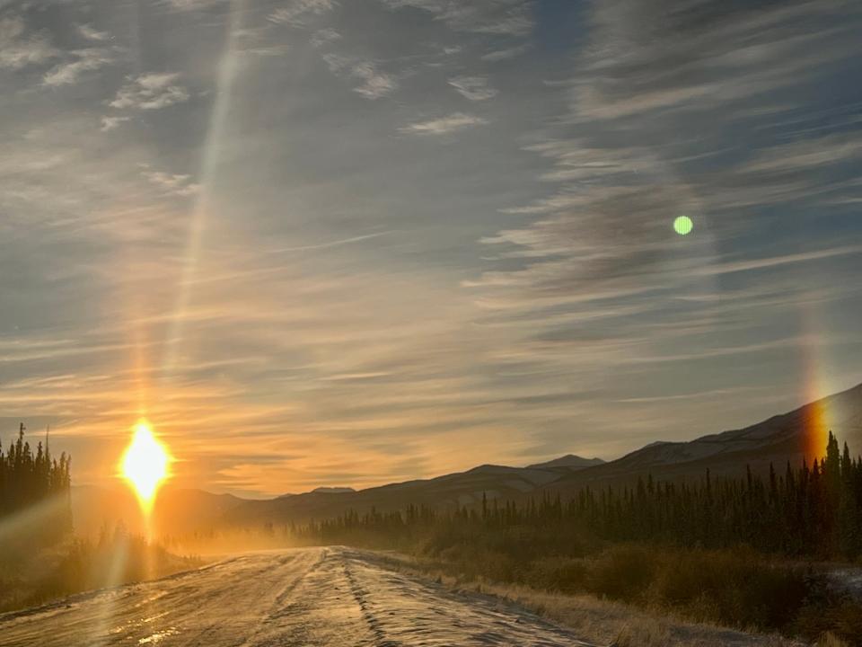 the sun setting on the road in canada