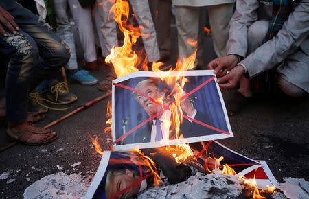 Protestors burn posters of U.S. President Donald Trump during a protest, organised by various religious organisations, against the U.S. decision to recognise Jerusalem as the capital of Israel, in New Delhi, India, December 17, 2017. REUTERS/Adnan Abidi