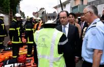 French President Francois Hollande (R) shakes hands with fire crews as he arrives in Saint-Etienne-du-Rouvray on July 26, 2016