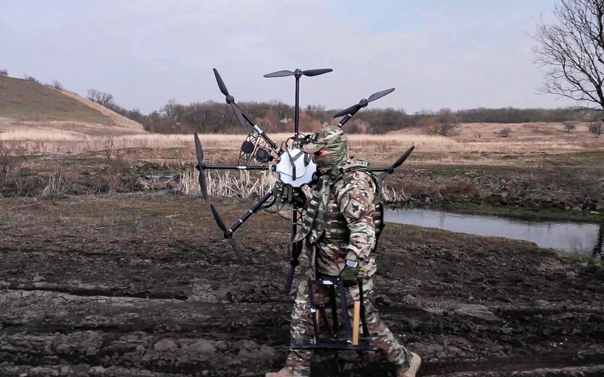 A Russian soldier carries a captured Ukrainian drone restored and modernized by the military at an undisclosed location in Ukraine