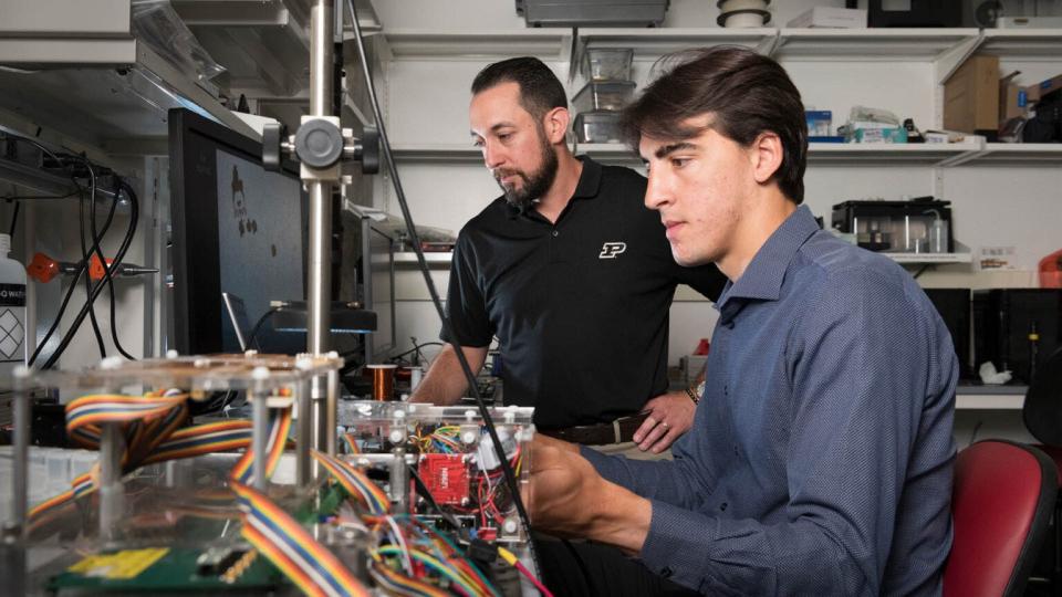Dave Cappelleri, professor of mechanical engineering (left), and postdoctoral researcher Georges Adam are breaking new ground in microrobotics with the Nanoscribe Photonic Professional GT2 3D printer.