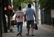 Wang and her husband Liu hold hands as they walk toward a hospital in Beijing, China, June 23, 2016. REUTERS/Kim Kyung-Hoon