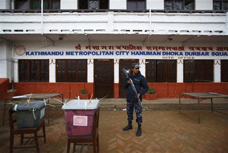 A Nepalese policeman stands guard in front of sealed ballot boxes stored awaiting transportation, after the completion of the Constituent Assembly election in Kathmandu November 19, 2013. REUTERS/Navesh Chitrakar