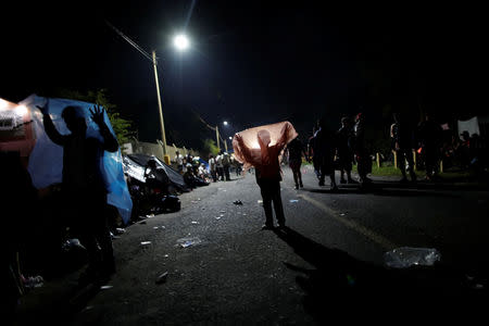 Honduran migrants, part of a caravan trying to reach the U.S., play with plastic bags on the bridge that connects Mexico and Guatemala in Ciudad Hidalgo, Mexico, October 19, 2018. REUTERS/Ueslei Marcelino