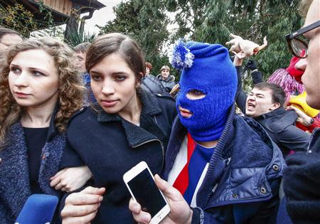 Russian punk band Pussy Riot members Maria Alyokhina (L) and Nadezhda Tolokonnikova (2nd L) along with a masked member speak to journalists during the 2014 Sochi Winter Olympics, in Adler February 20, 2014. REUTERS/Shamil Zhumatov